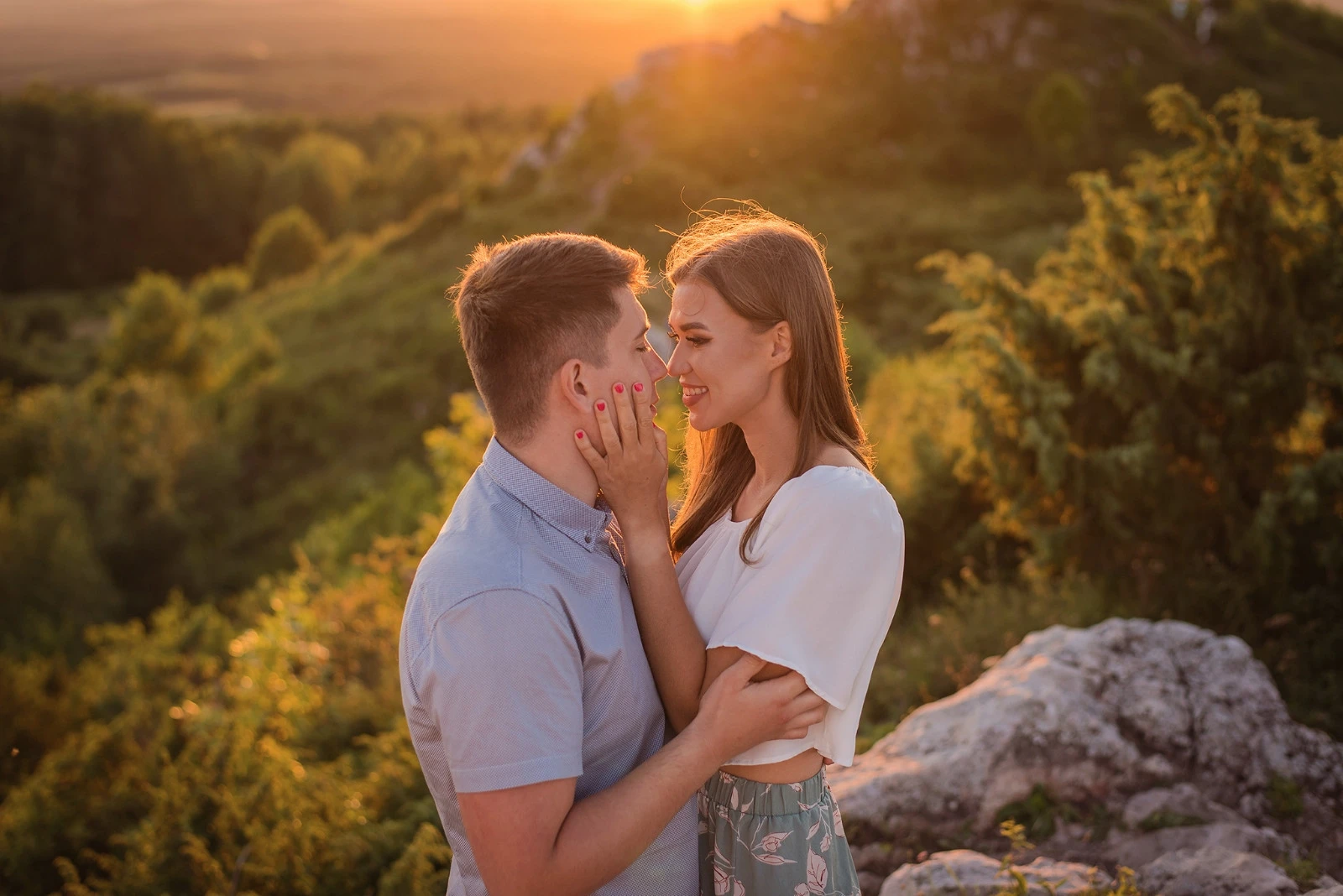 Narzeczeńska sesja plenerowa w górach podczas złotej godziny – zakochana para w objęciach