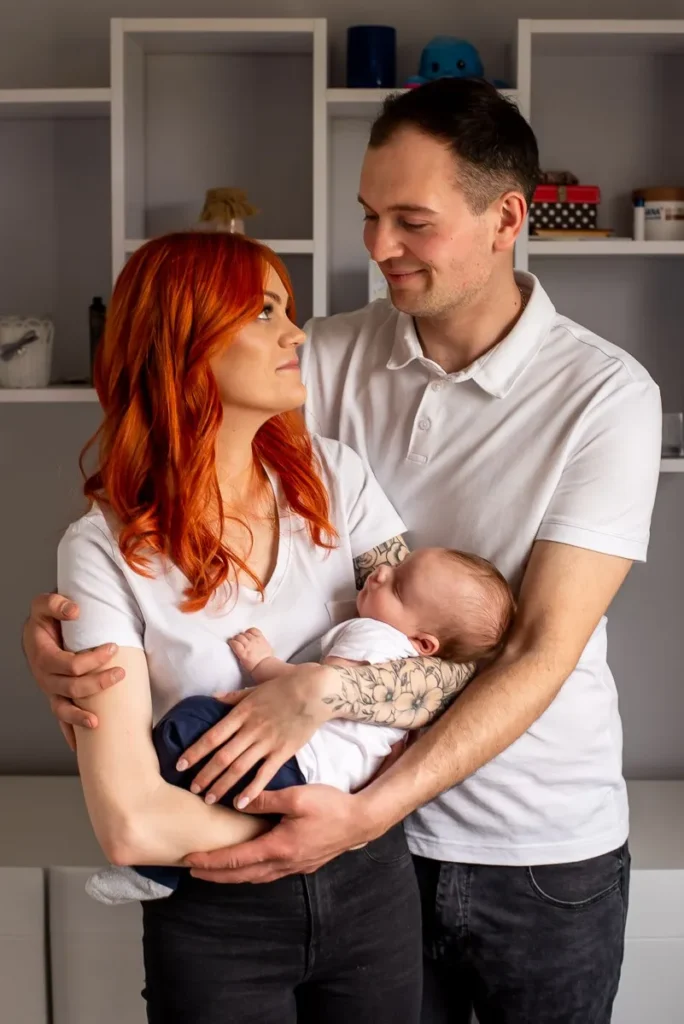 Rodzinna sesja domowa – rodzice z noworodkiem na rękach