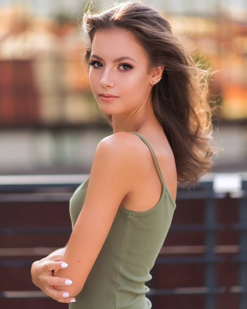 Portret młodej kobiety w zielonym topie, patrzącej w stronę obiektywu – naturalna fotografia plenerowa, Jacek Waldon Fotografia